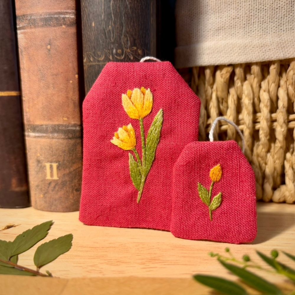 Bookmark shaped as a tea bag, with yellow tulips embroidered on it.