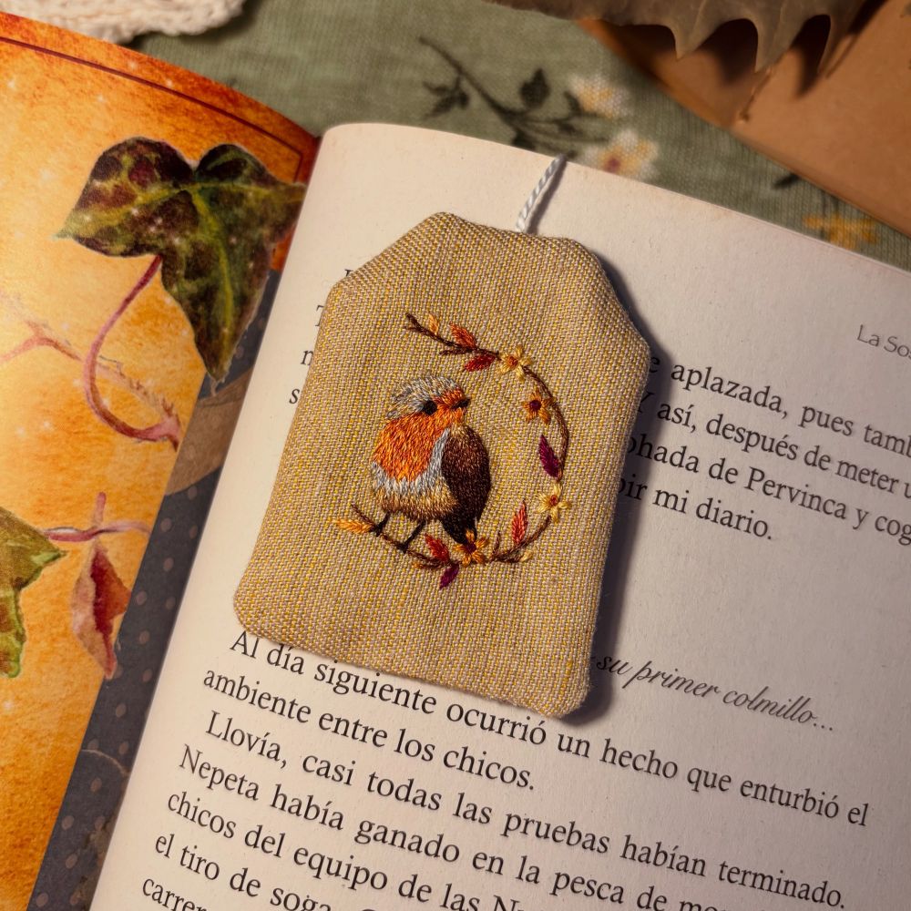 Bookmark shaped as a tea bag, with a robin embroidered on it.
