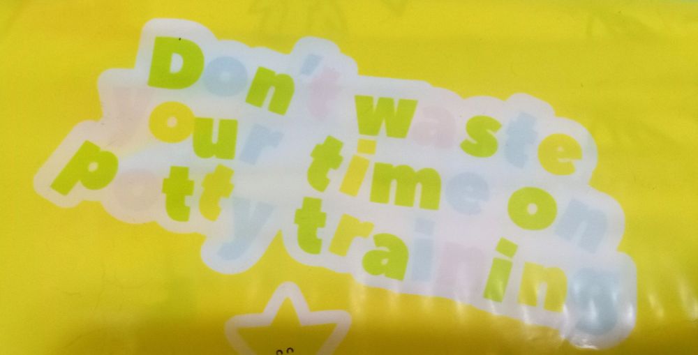 a cropped photo of a package of kiddo brand's "playtime" ABDL diapers, focusing on a bit of text reading "don't waste your time on potty training!"