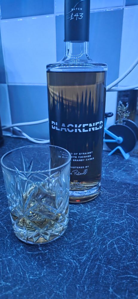 A bottle of blackened bourbon,  a glass. It's been a week and it's only Wednesday. 