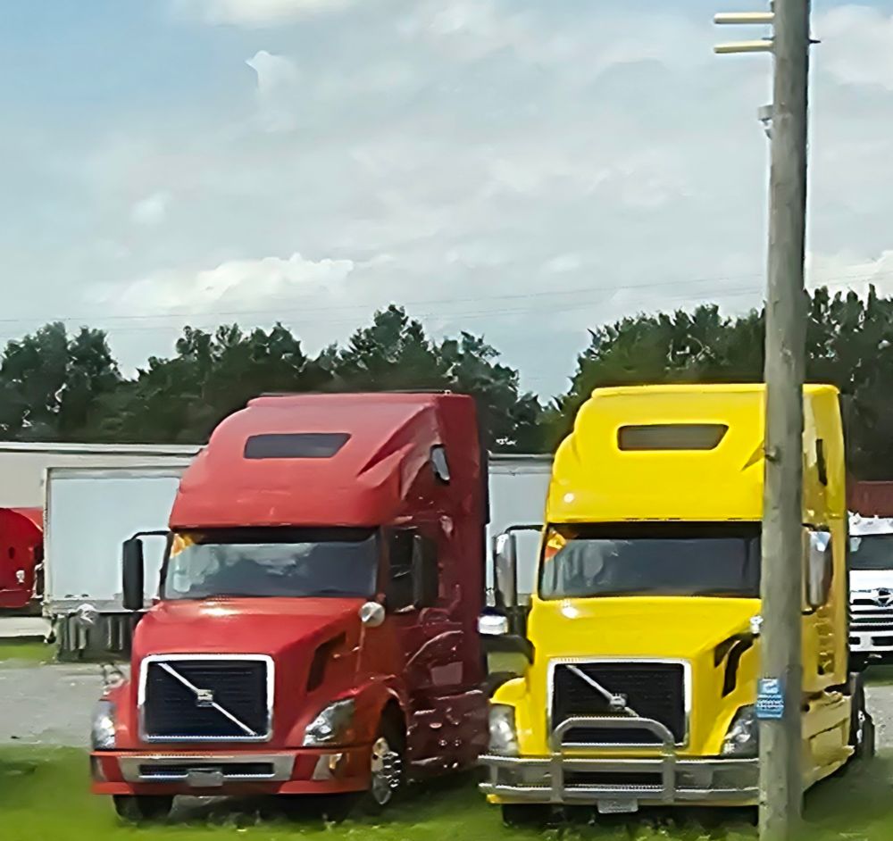 A red lorry next to a yellow lorry