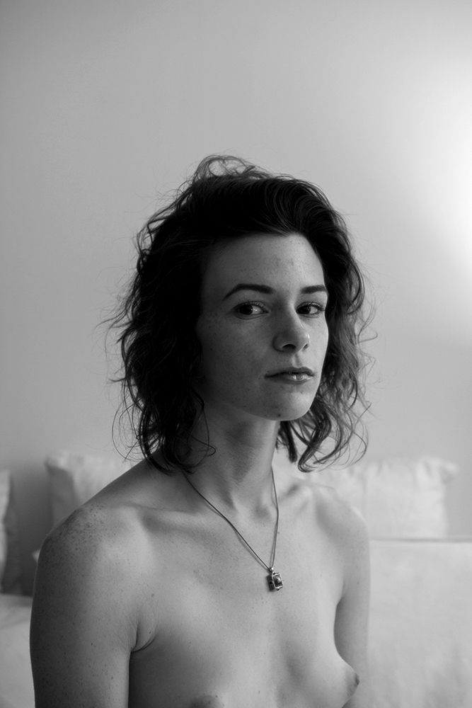 Black and white portrait of topless Tmpls, winter lights, a smirk?, freckles