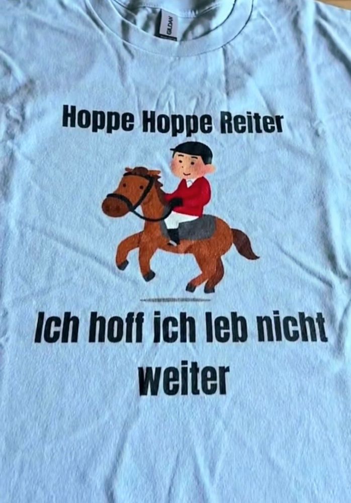 T-Shirt mit dem Aufdruck „Hoppe Hoppe Reiter – Ich hoff ich leb nicht weiter“ mit einer kinderbuchtypischen Illustration eines Reiters auf seinem Pferd