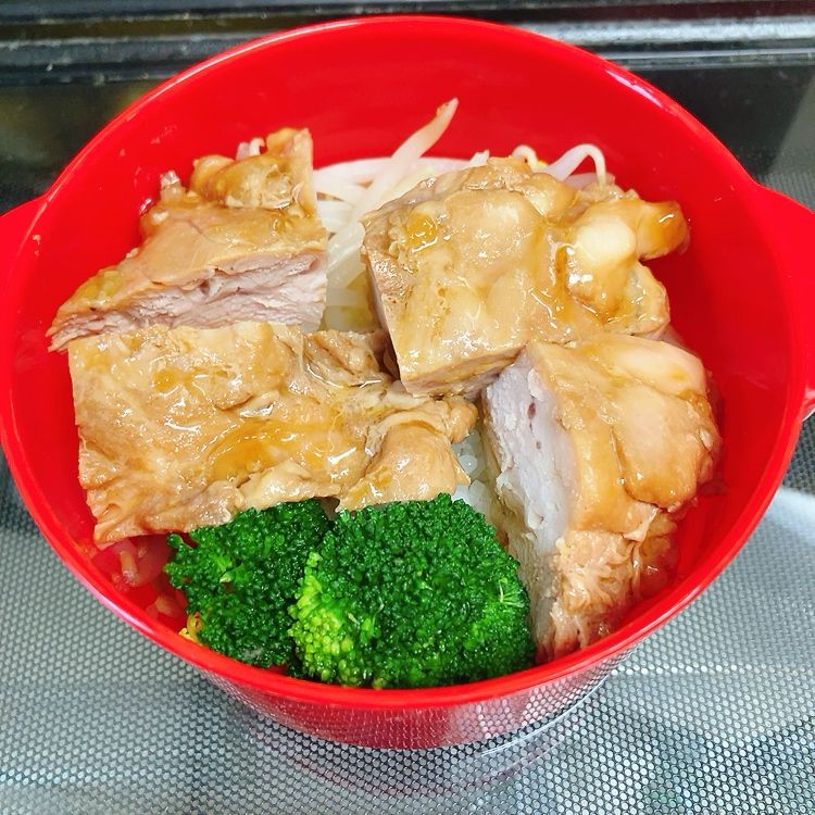 お弁当
赤い丸型の弁当箱に鶏ももの照り焼き、ブロッコリー、茹でもやしが入ってる。ごはんは下に入っているがほぼ見えない。