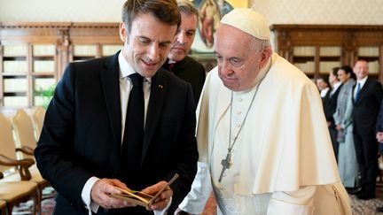 Emmanuel Macron montrant un carnet au Pape