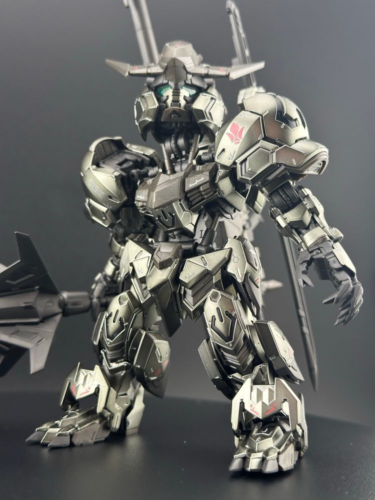 A light box photo of the master grade super deformed Barbatos (Iron-Blooded Coating) Gundam plastic model kit, from Iron-Blooded Orphans. A full-body frontal shot, with particular focus on the legs and feet 