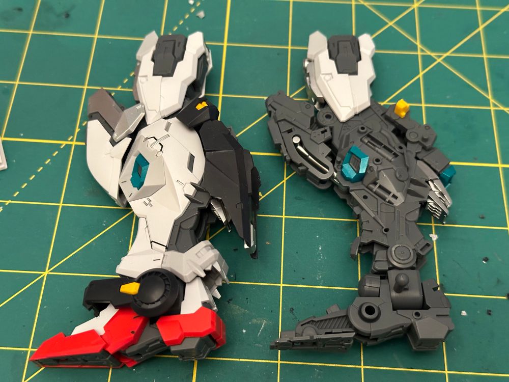 A photo of two assembled legs from the In-Era Thunderbolt 2.0 plastic model kit. The left is armored and the right is just the inner frame 