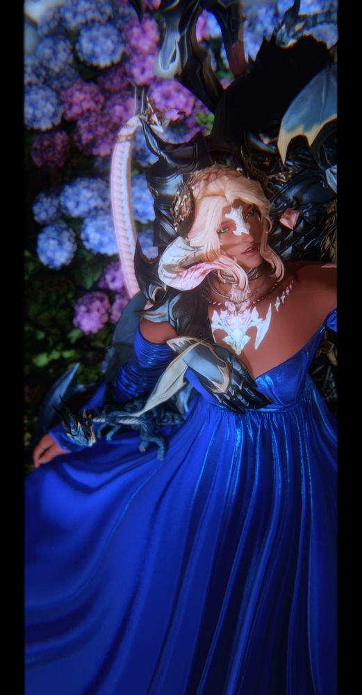 Another angle of the same picture, showing Ryuhiko looking up at her husband with a smile upon her face, the pair flanked by their dragon broodlings flying around them. Flowers and foliage frame the couple.