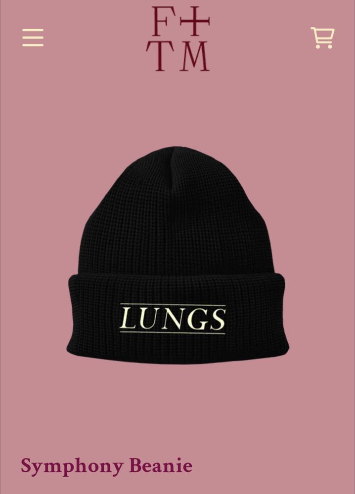 A black beanie in the Florence and the machine online shop with the word LUNGS embroidered in white. 