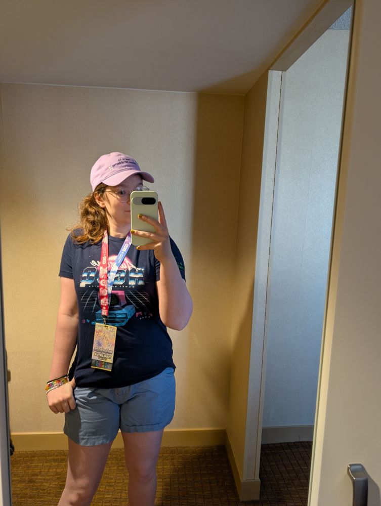 A mirror selfie with the AGDQ2023 runner shirt and a hat that says "here to cause problems".