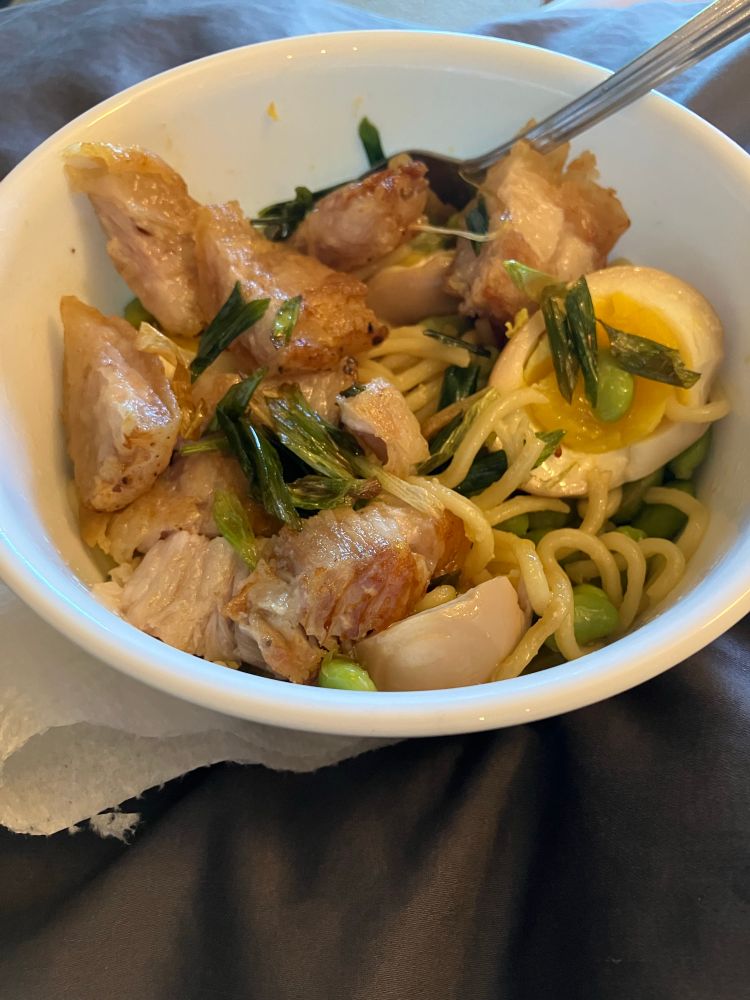 Bowl of Scallion oil noodles w/pork belly, ramen egg and fried scallions on top.