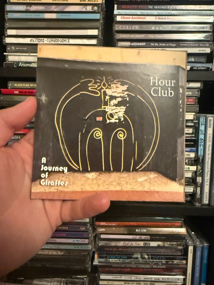 A Journey of Giraffes - Hour Club CD set with CD shelving unit and CDs in background.