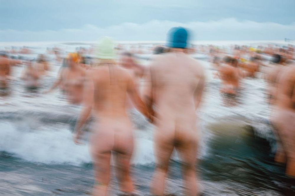 People participating in the North East Skinny Dip event, standing in the sea.