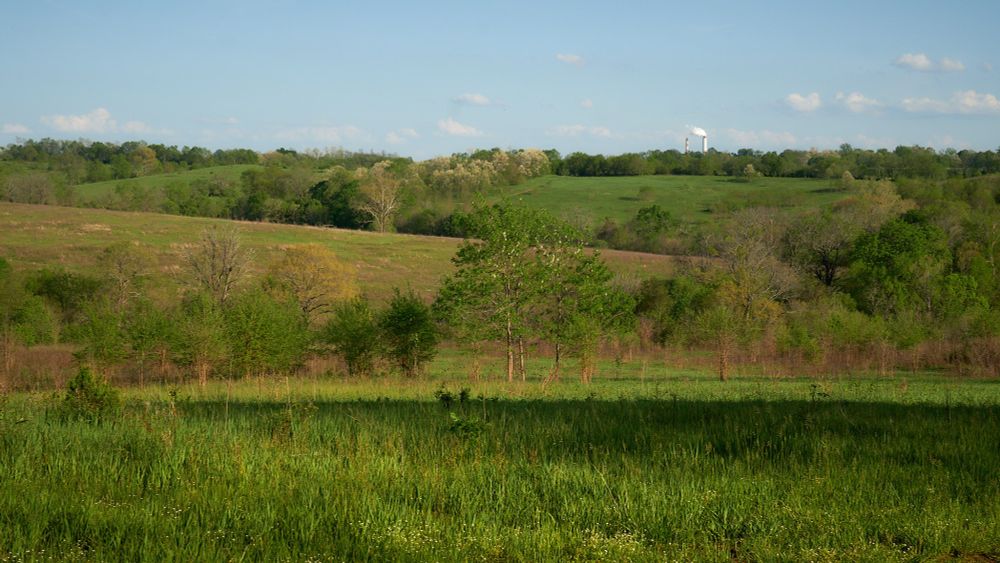 Looking across the rolling hills at Shaker Village, with the E.W. Brown Generating Station in the distance.
