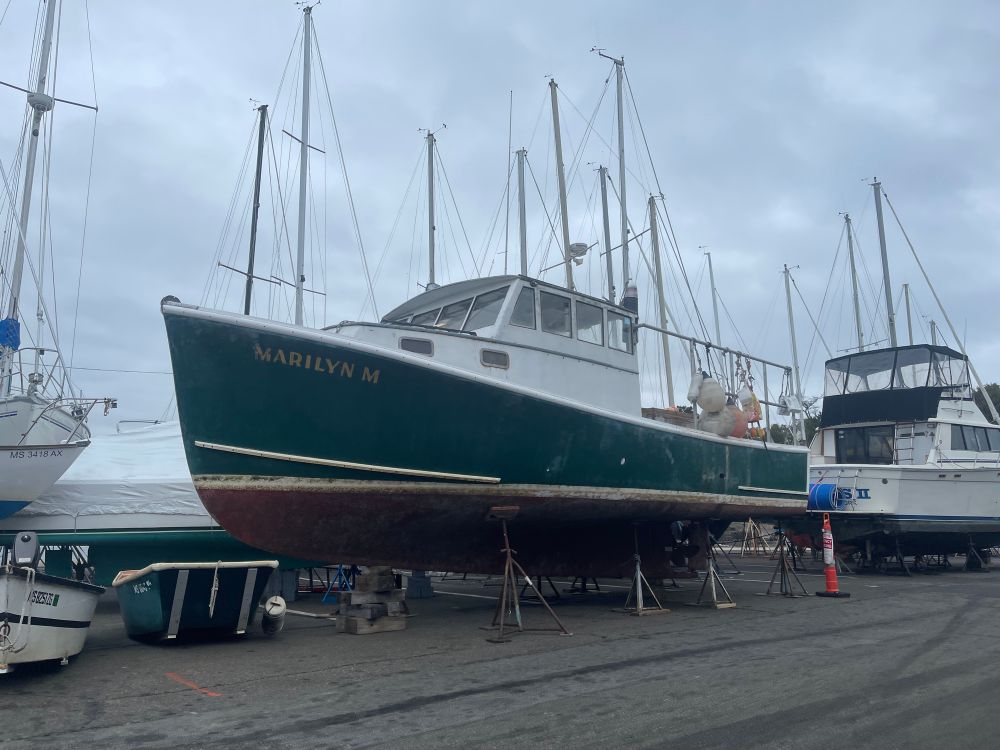 10/12/2025 1:45pm lobster boat recently pulled from the water. Boat is elevated upright with supports.