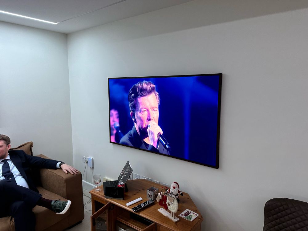 A television showing Rick Astley singing.