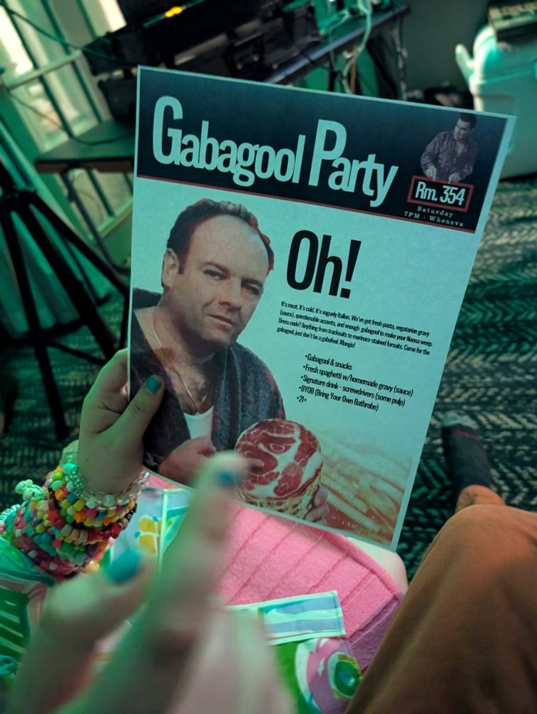 pov of someone else's hands holding a "gabagool party" flyer in a room party, it has a pic of uhh a soprano on it i think. it advertises gabagool, spaghetti, and screwdrivers 