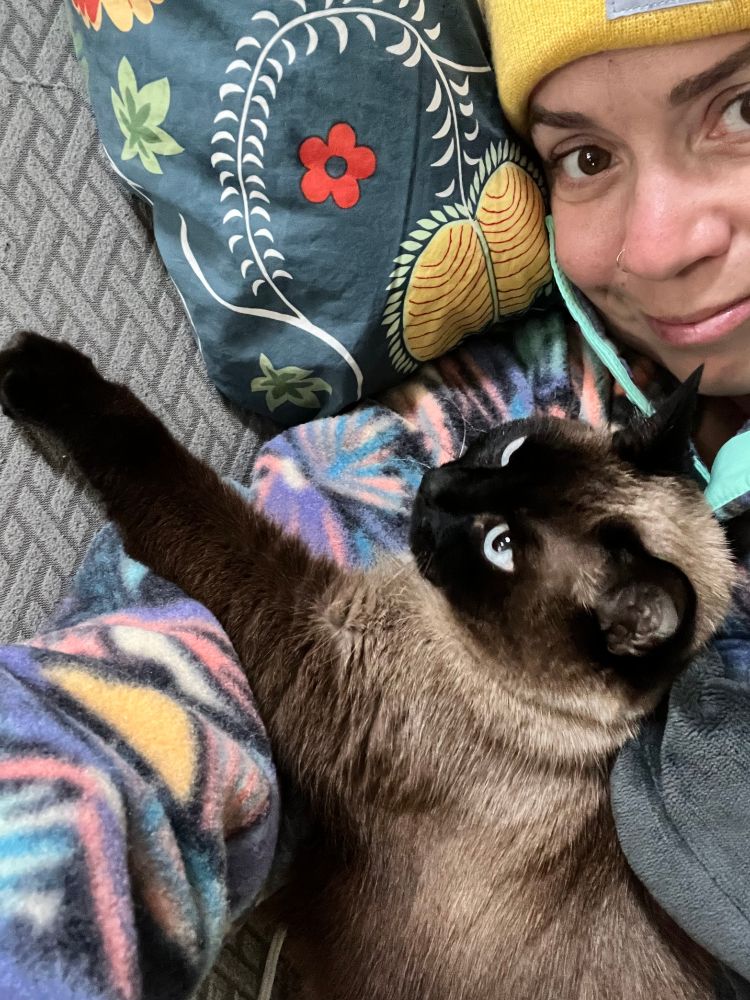 me, holding Poppy, a beautiful Siamese cat 