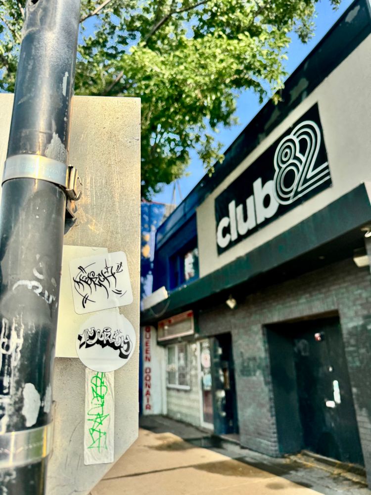 Merch stickers on a pole off Whyte Ave in Edmonton