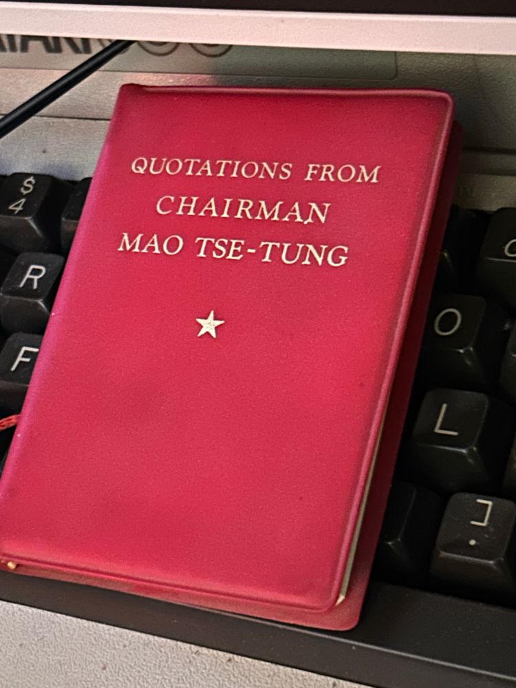 photo of Chairman Mao Zedong’s Little Red Book, also known by its official title: Quotations From Chairman Mao Tse-Tung. it is resting behind the Atari 800 home computer. 