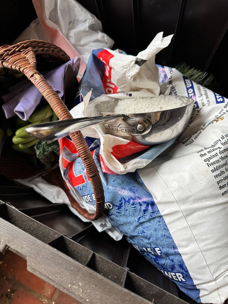 A utility holds gloves and a bad of snow melt salt, plus a nice saucepan being used to scoop the salt. 
