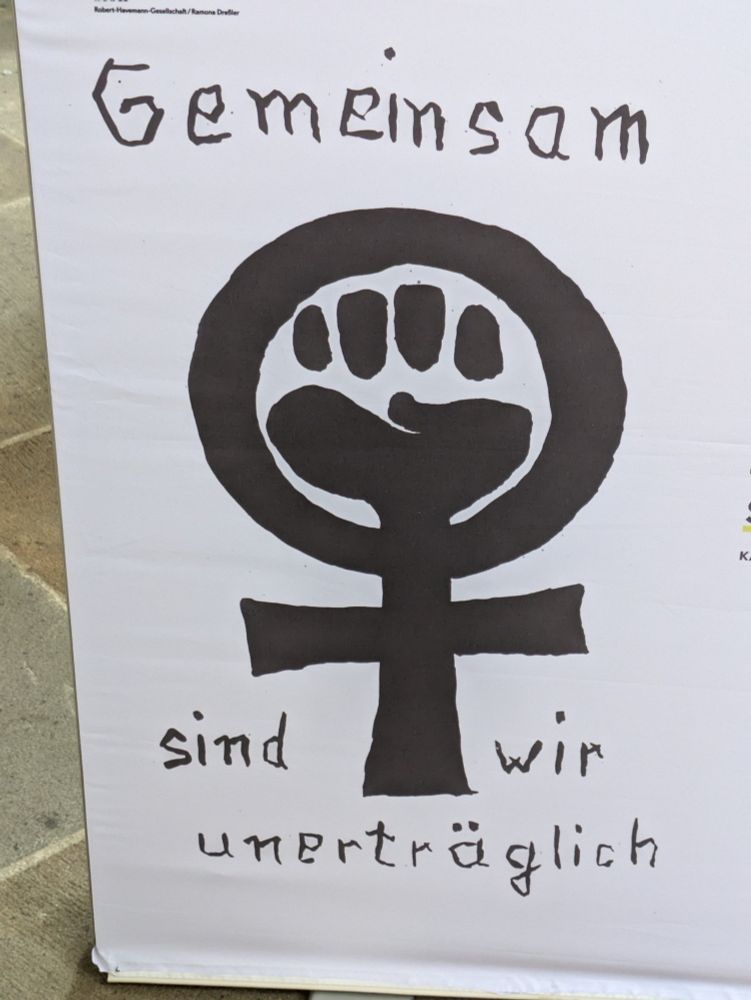 Plakattext: Gemeinsam sind wir unerträglich über und unter Frauenzeichen mit geballter Faust