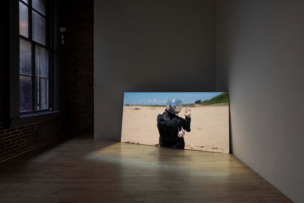 installation image of stop motion animation installed at HESSE FLATOW, NY, NY showing two characters who share a disco ball head as they begin to dance a tango in the dunes of Provincetown