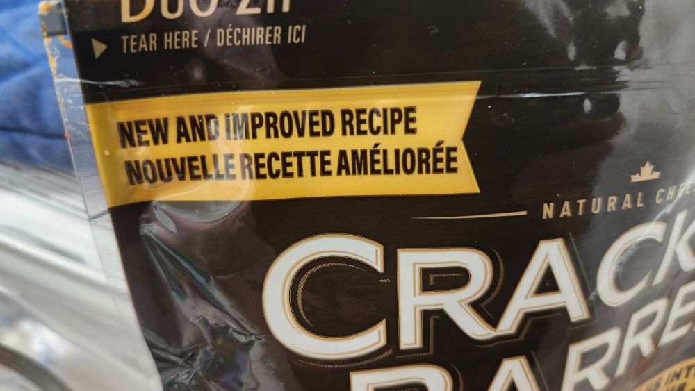 a close up image of a bag of cracker barrel shredded cheese. The image is focused on a part of the bag that says "new and improved recipe"