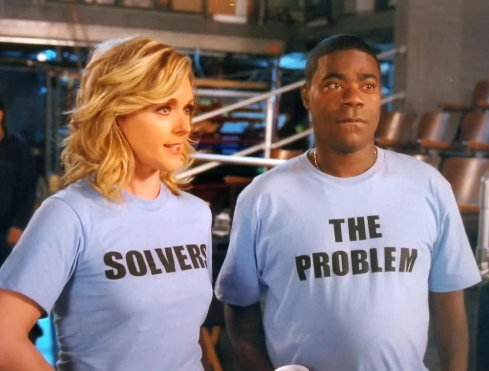"The Problem Solvers" from 30 Rock cannot figure out how to solve the problem of their t-shirts being in reverse order.