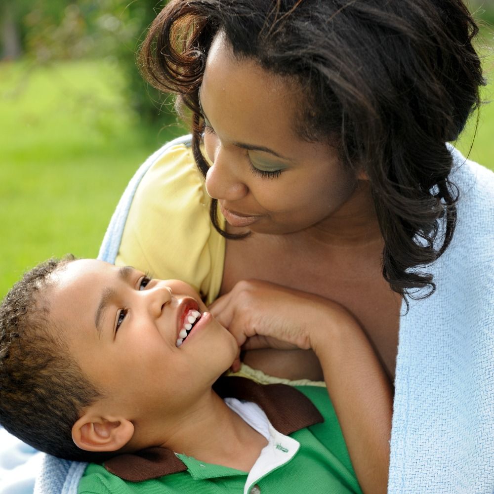 An adult holds a child in an outdoor setting 