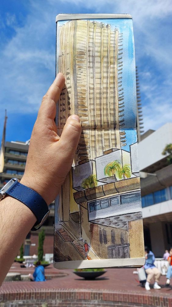 Old photo of me holding a drawing of one of Barbican's buildings in front of it. I was cooking myself alive that summer.
