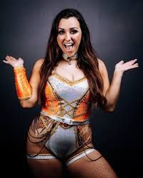 brunette woman in an orange and white outfit 