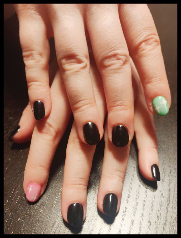 Ein Foto meiner beiden Hände, in voller Pracht der Wurstfinger. Zu sehen sind die Fingernägel. Die meisten sind schwarz lackiert, nur die Zeigefinger sind jeweils in Pink und Grün lackiert mit weißen Sternchen. Ein bisschen frühlingshaftes Magical Girl Feeling. 