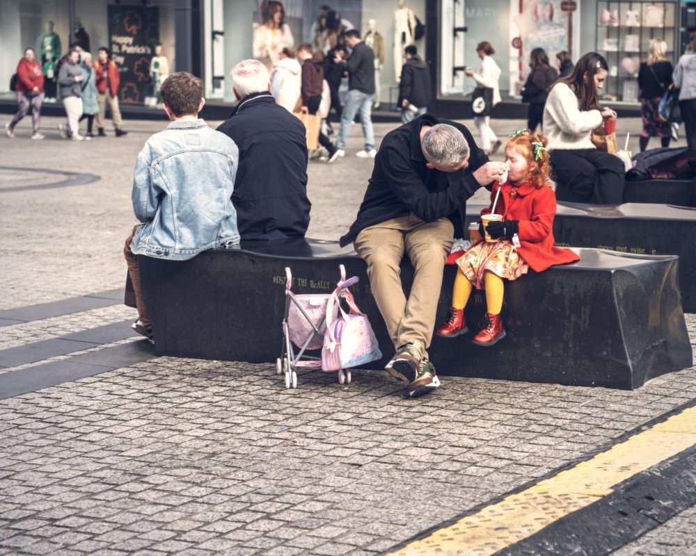 Father cleaning daughter’s face. Waterford City Centre, Ireland. 