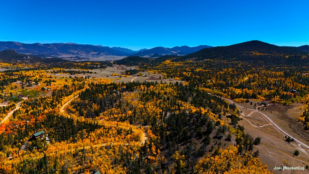 Drone aerial shot of a part of south park Colorado. The leaves have started to change into their gold phase right before turning red.