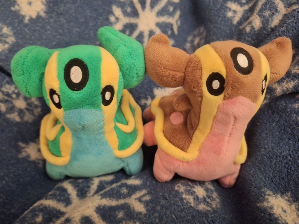 a photo of two Gastrodon plushies, East Sea (blue) is to the left and West Sea (pink) is to the right