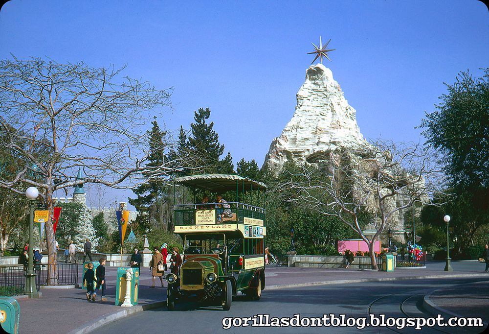 1968 photograph of the Omnibus in Disneyland's Central Plaza, with the Christmas Star atop the Matterhorn in the background.