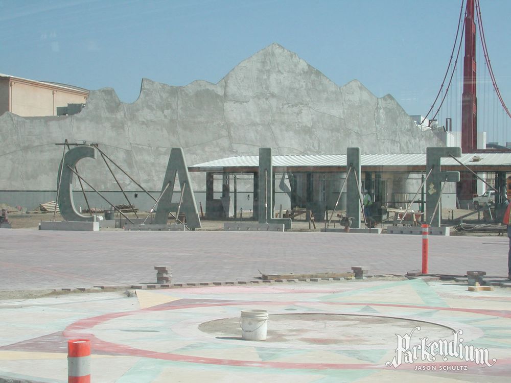 Photograph through a construction fence window of the CALIF letters (of the CALIFORNIA sign in front of the Disney's California Adventure entrance turnstiles) held in place as construction continues.