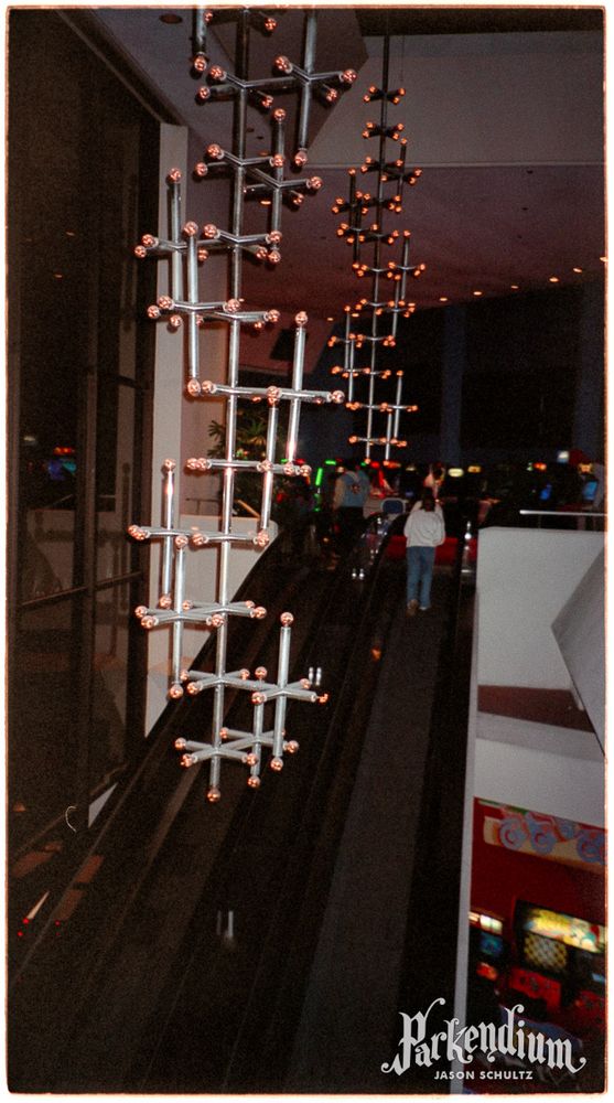 Photograph of stick-like lighting fixtures hanging from the Starcade ceiling in Tomorrowland at Disneyland.