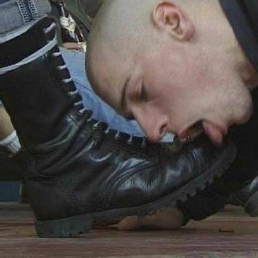 Ein Typ, der einer Person den Stiefel sauber leckt.