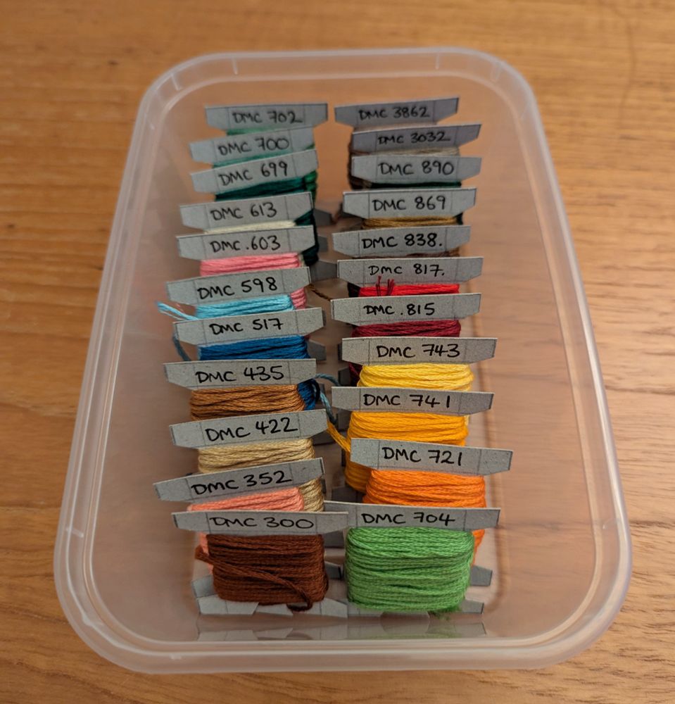 The embroidery threads from the photo above, now wound onto home-made cardboard bobbins and arranged into a plastic box in DMC number order.