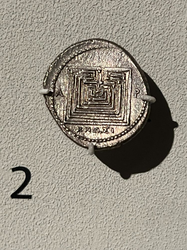 Silver coin with a square labyrinth, letters A and P (Greek R) on either side of the image of the labyrinth, and KNOSI below.  