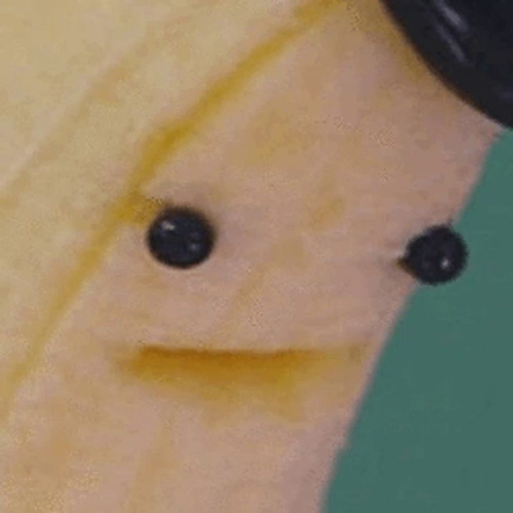 a close up of a banana with a face on it and two eyes .