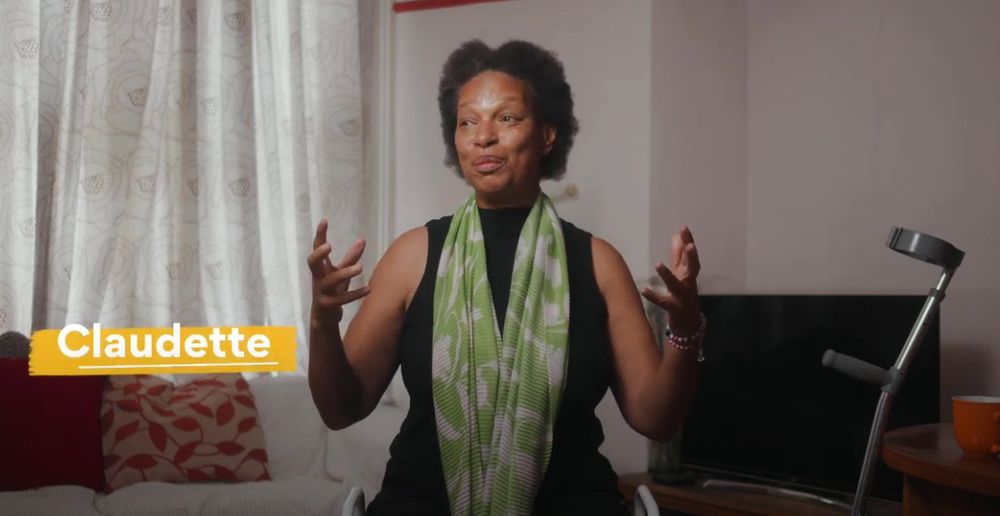 Claudette, an older woman sitting in her living room being interviewed
