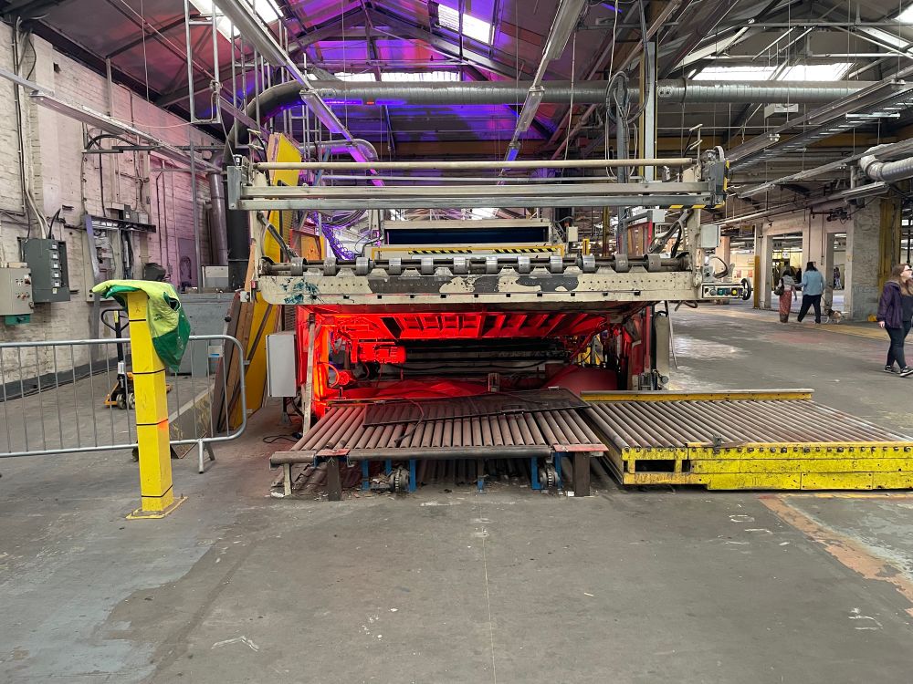 A large piece of factory equipment lit red inside like a large mouth