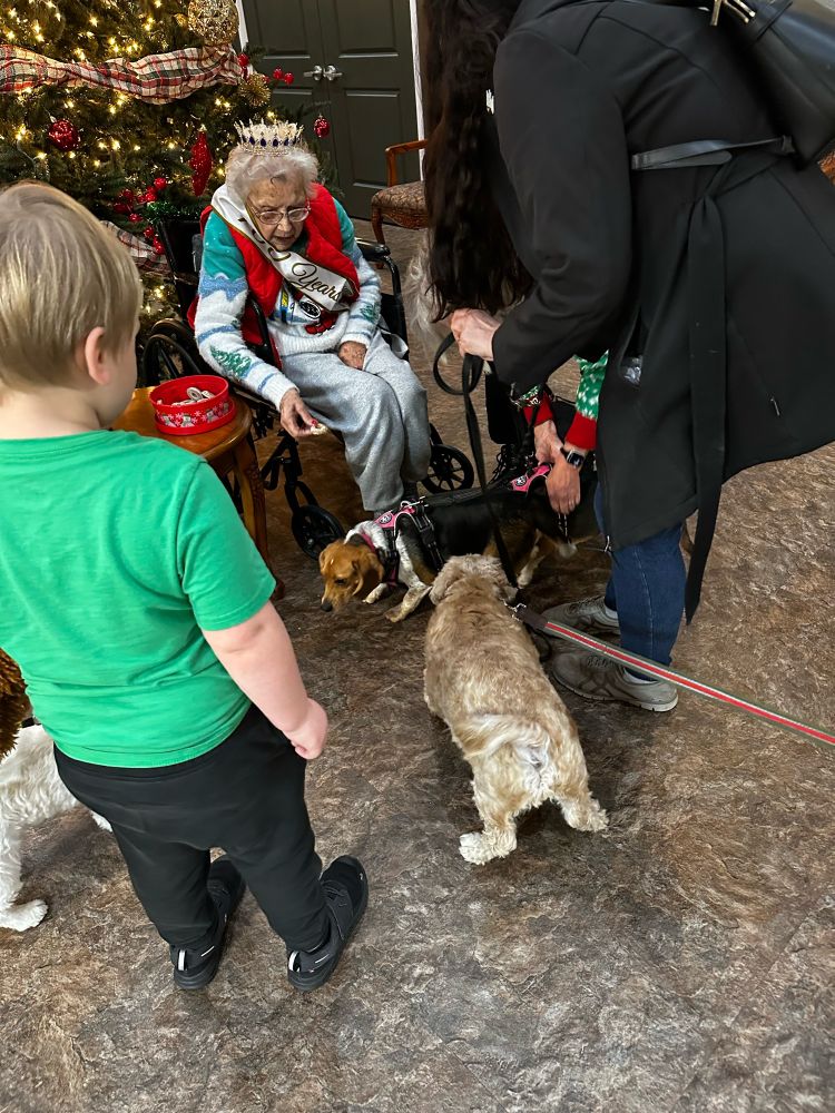 100 year old celebrating surrounded by dogs and people 