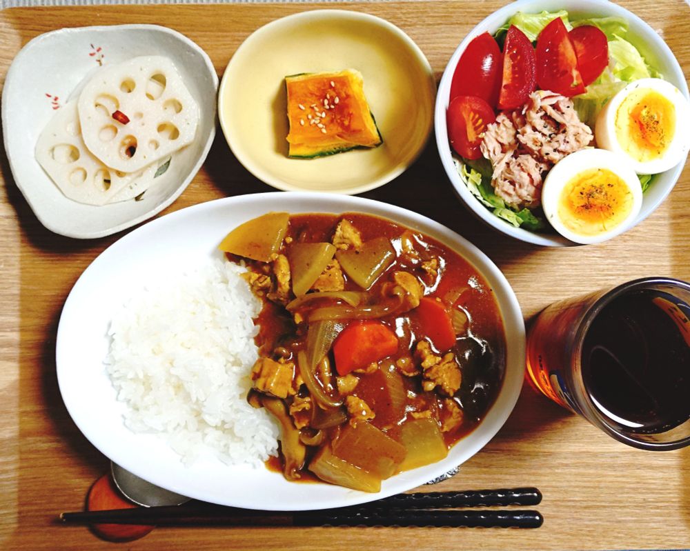 2025/12/07　の晩ごはんの写真。
酢蓮、蒸しかぼちゃ、ミニトマトとツナ、ゆで卵、レタスのサラダ。
麦茶。楕円の皿に盛られたカレーライス。左側にごはん、右側にカレーが盛られている。具材は、人参、しめじ、豚肉、大根、しめじ（ジャガイモなどがなかったため）