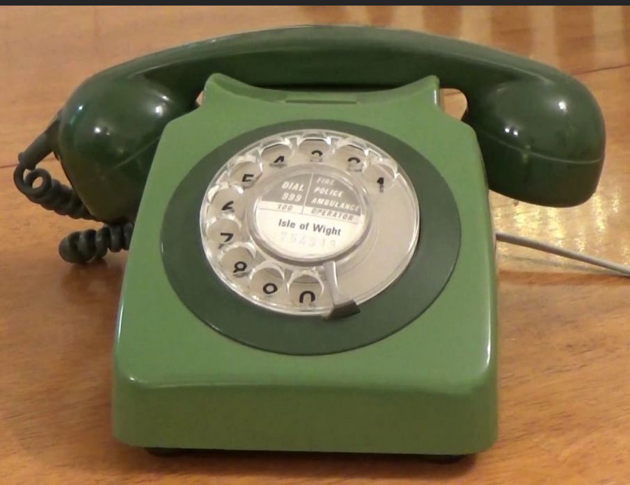A green rotary dial telephone from the UK
