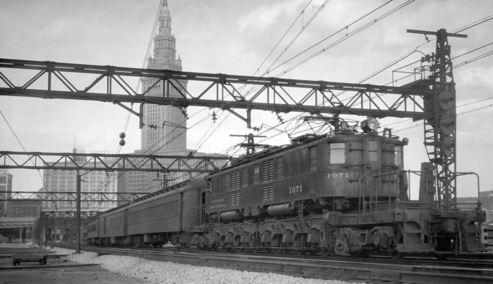 Cleveland Union Terminal locomotive 1071 pulling a consist westbound with the Terminal Tower in the background.