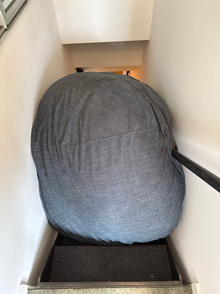 Large memory foam bean bag that weighs 80lbs stuck in the middle of a stair case.
